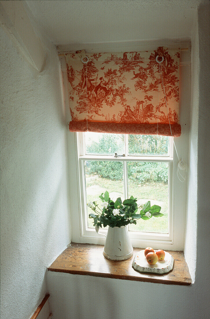 Sprossenfenster mit Blick auf den Garten im Treppenhaus und Blumenvase auf der Fensterbank