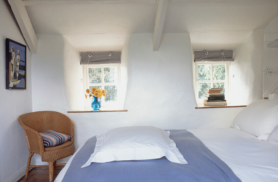 Rustikales Schlafzimmer im Landhausstil mit Doppelbett und kleinen Fenstern