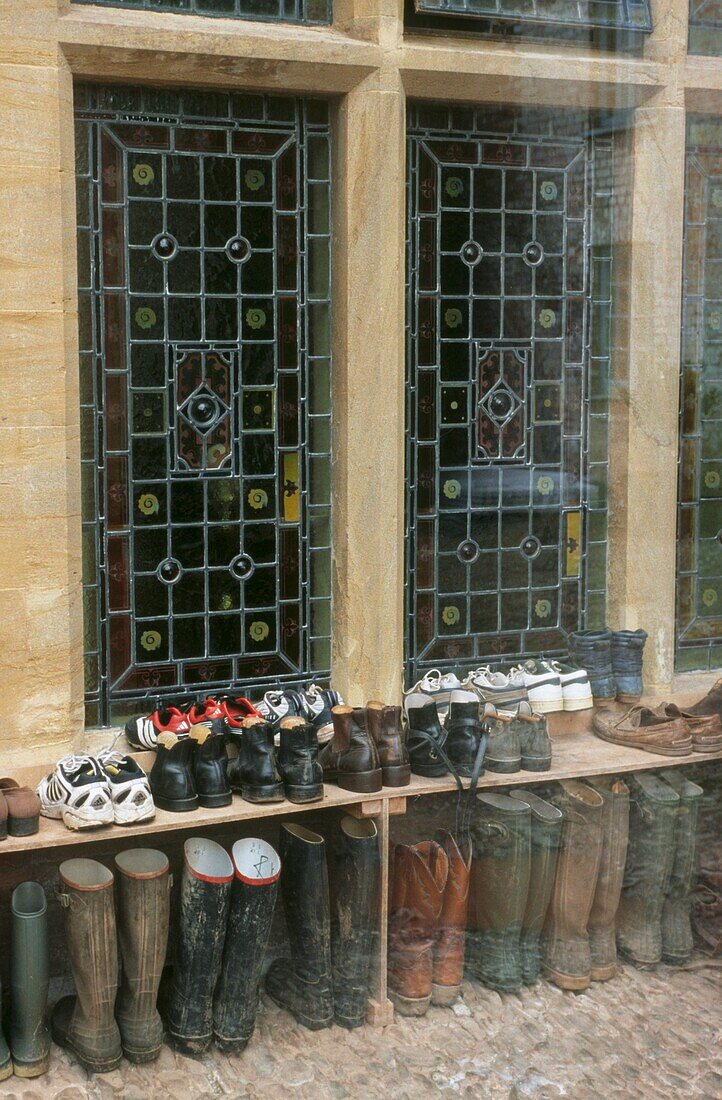 Reitstiefel und Schuhe vor einem Bleiglasfenster
