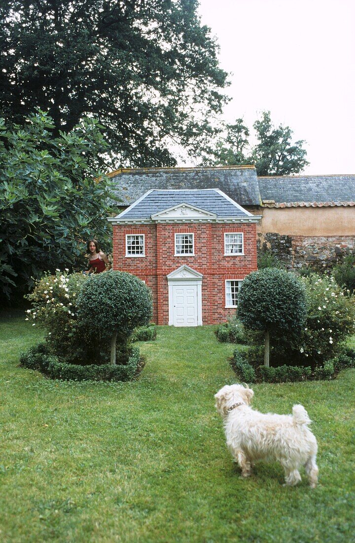 Georgianisches Miniaturhaus im Garten mit weißem Scottie-Hund