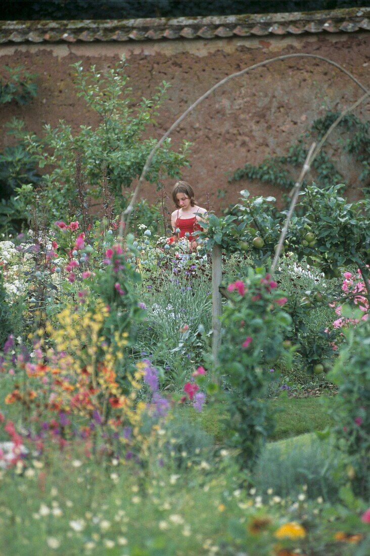 Walled flower garden with young girl