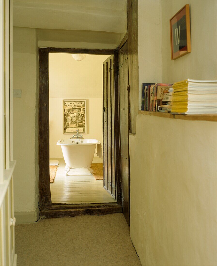 View of roll top bath from whitewashed passageway