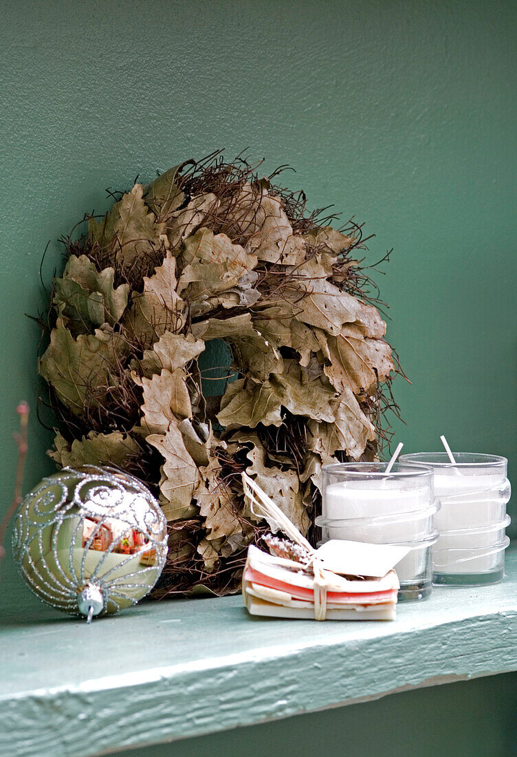 Christmas wreath of dried leaves with candles and a silver bauble