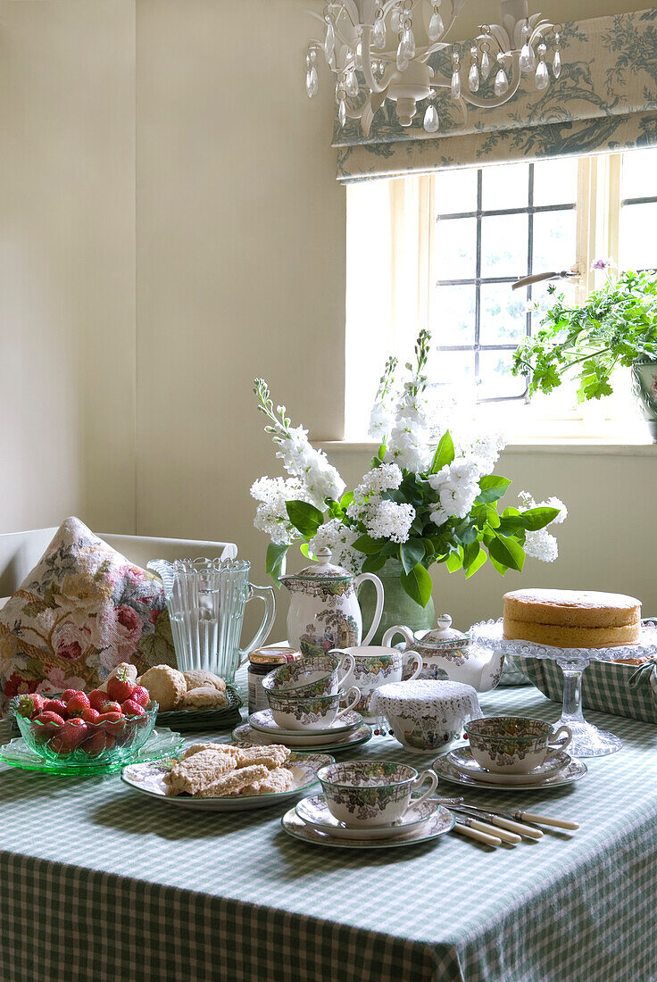 Kitchen table with green checked cloth set for afternoon tea