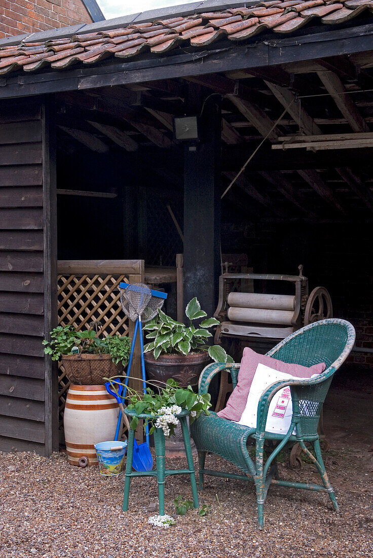 Wicker chair and fishing nets with mangle in rural outhouse