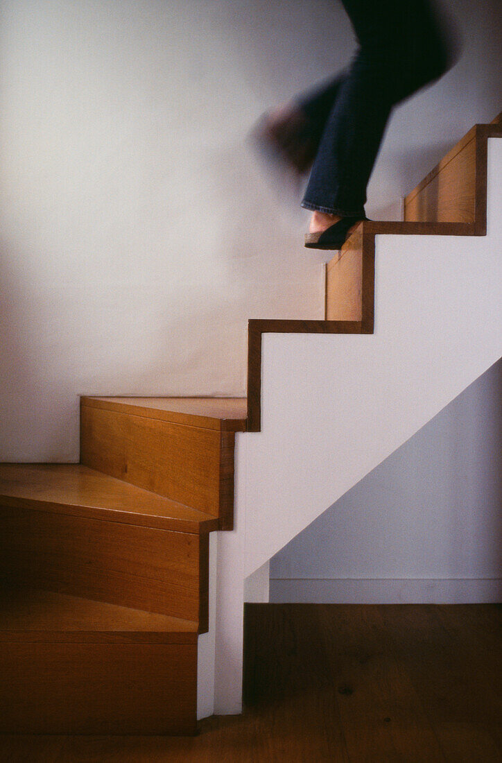 Woman walking up modern staircase