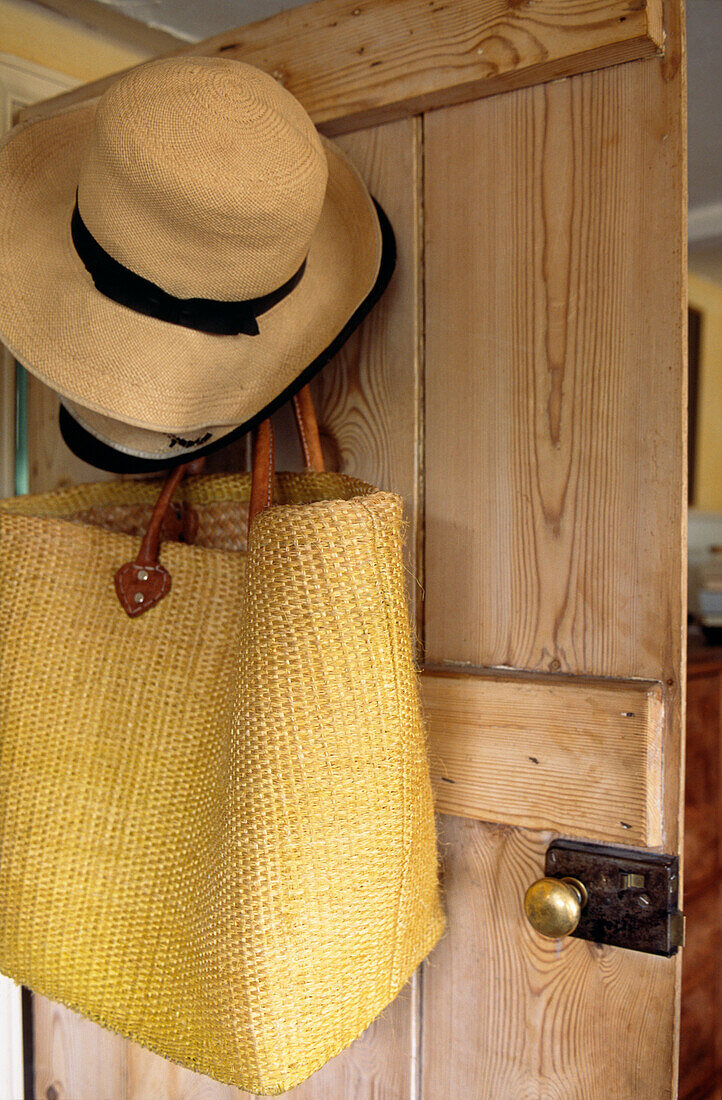 Sunhat and shopping bag hang on back of kitchen door