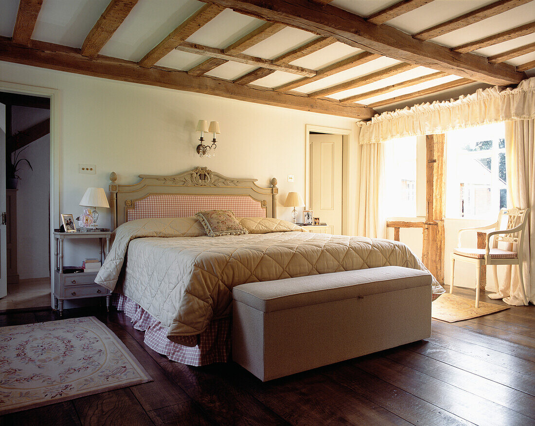 Schlafzimmer mit gestepptem Bettbezug, Balkendecke und Deckenkasten