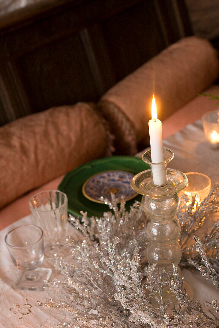 Detail des Weihnachtstisches mit brennender Kerze und silbernem Tafelaufsatz