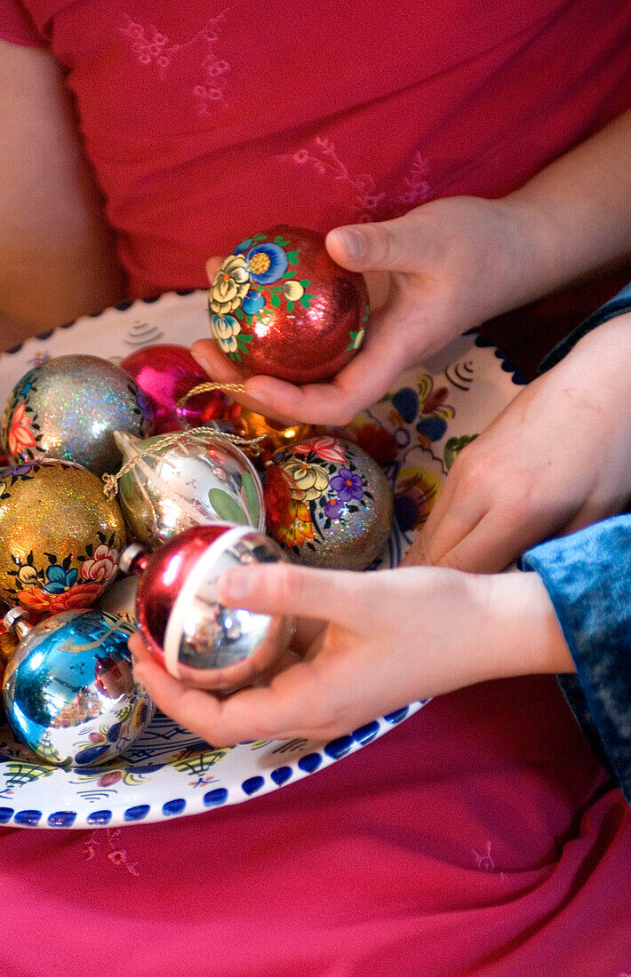 Girls choosing vintage christmas baubles from a bowl