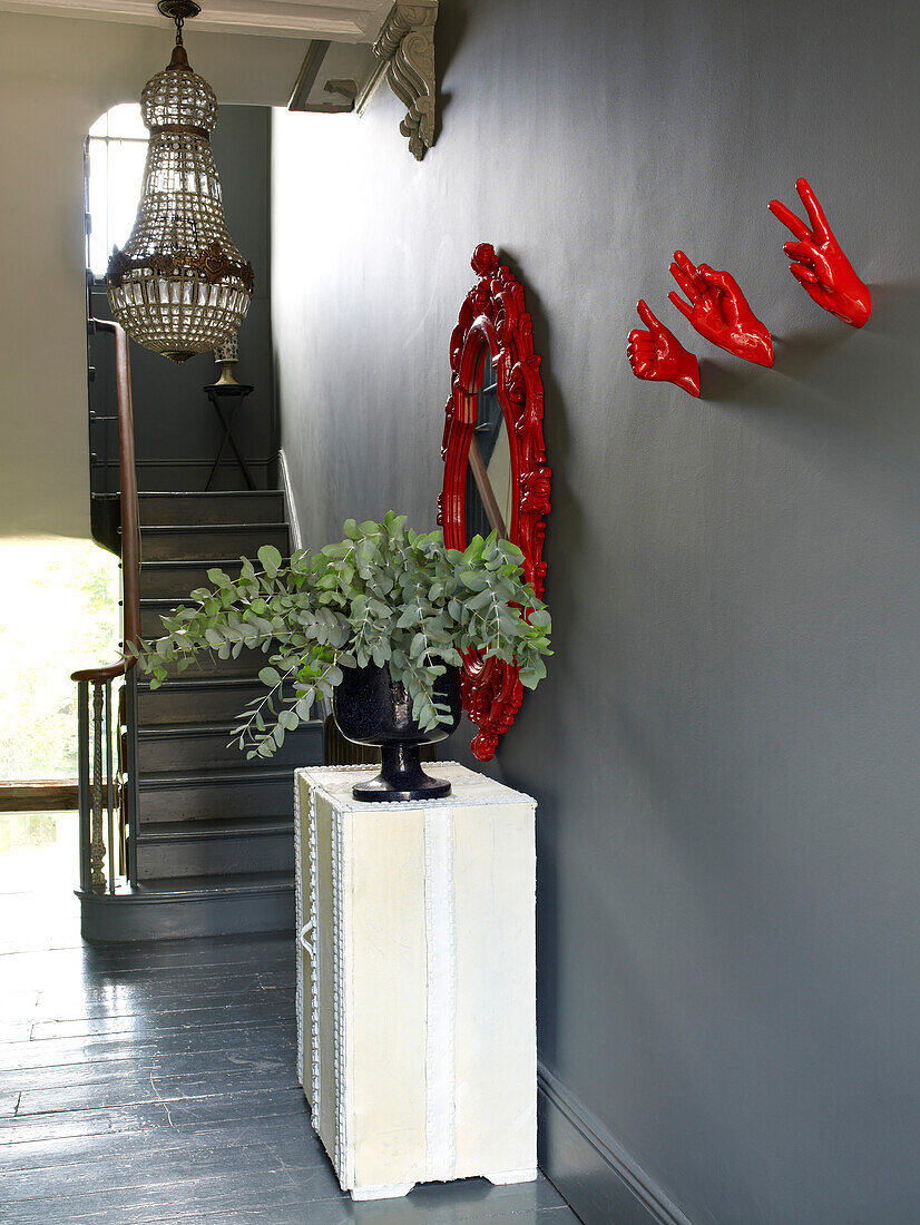 Landing painted in neutral grey with bright red cast hand sculpture and mirror