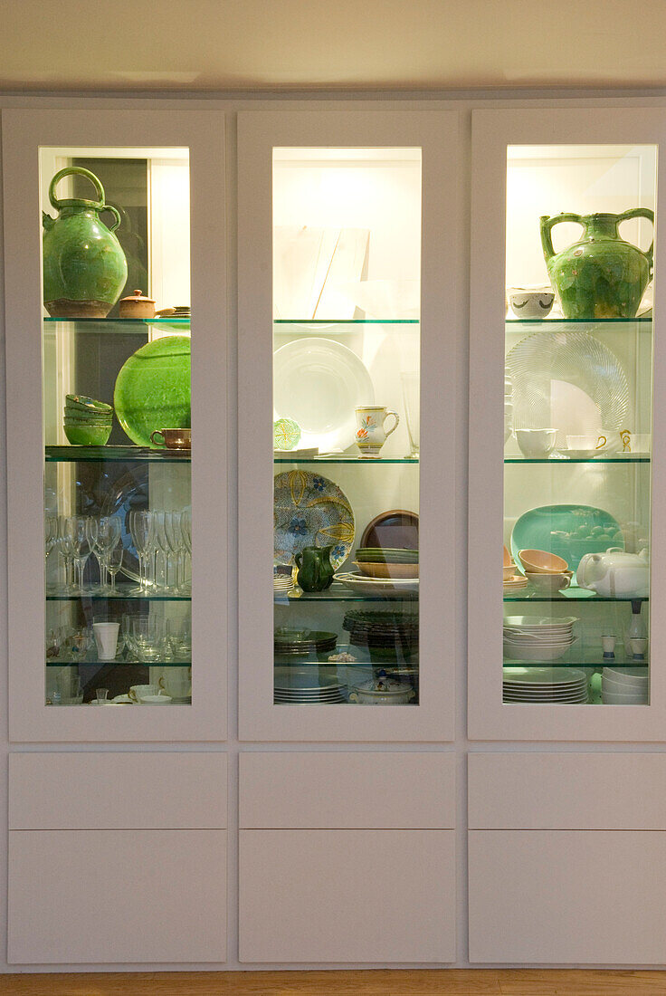 Lime green pottery in white display cabinet