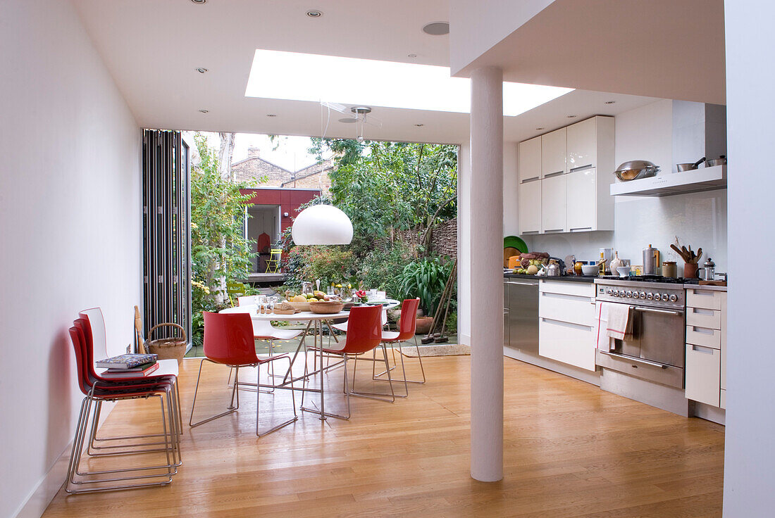 Rote Stühle am Tisch in einer modernen Küchenerweiterung in London