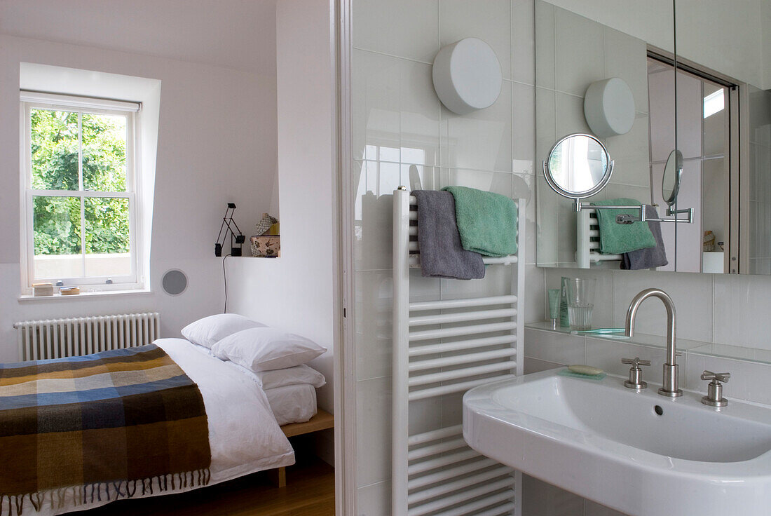 White en suite bathroom and bedroom with checked blanket bed covering