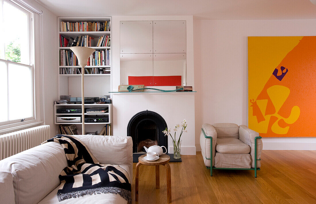 Sofa and armchair in open plan house with artwork