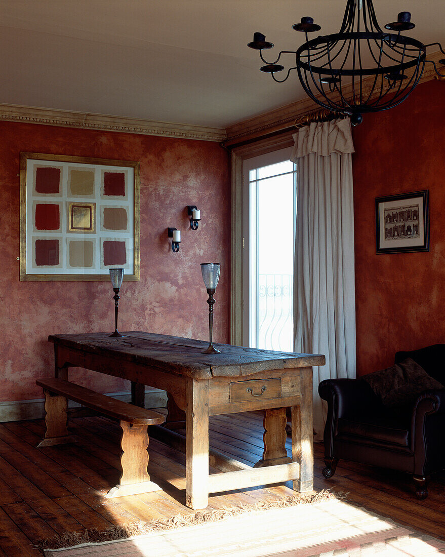 Rustikaler Holztisch in rotem Wohnzimmer mit weißen Vorhängen