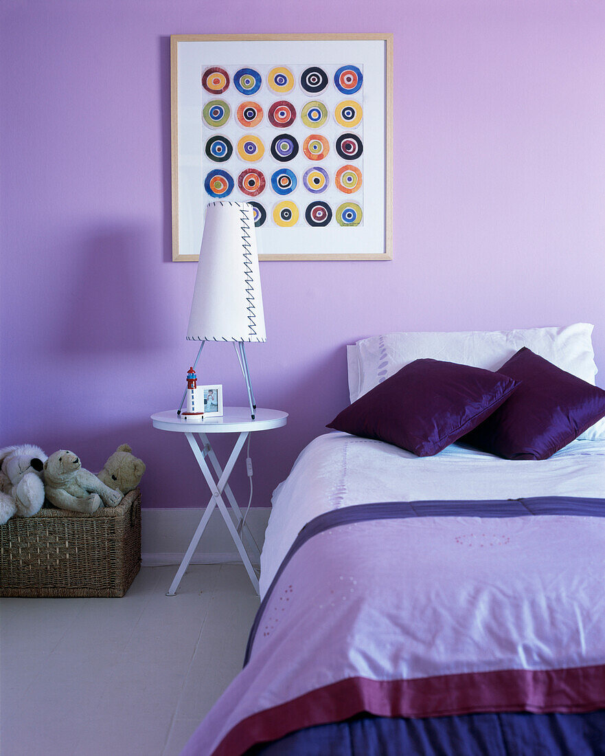 Single bed and artwork with toy box in lilac bedroom