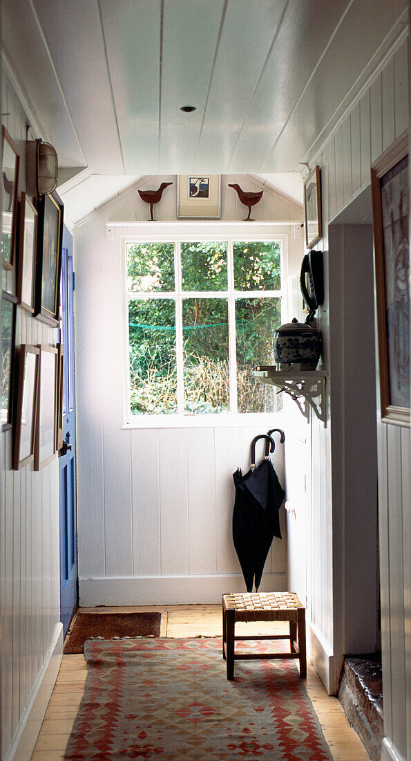 White panelled hallway and windowpanes with umbrellas