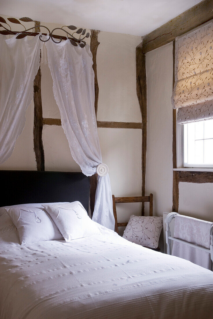 Schlafzimmer mit weißer Bettwäsche und Vintage-Spitzenhimmel