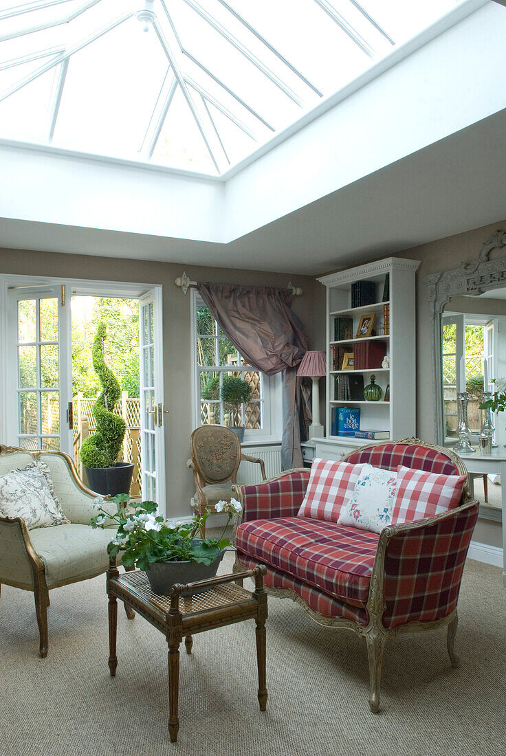 Sitting room extension with antique French sofa in an Anta tartan and fauteuil under roof lantern skylight