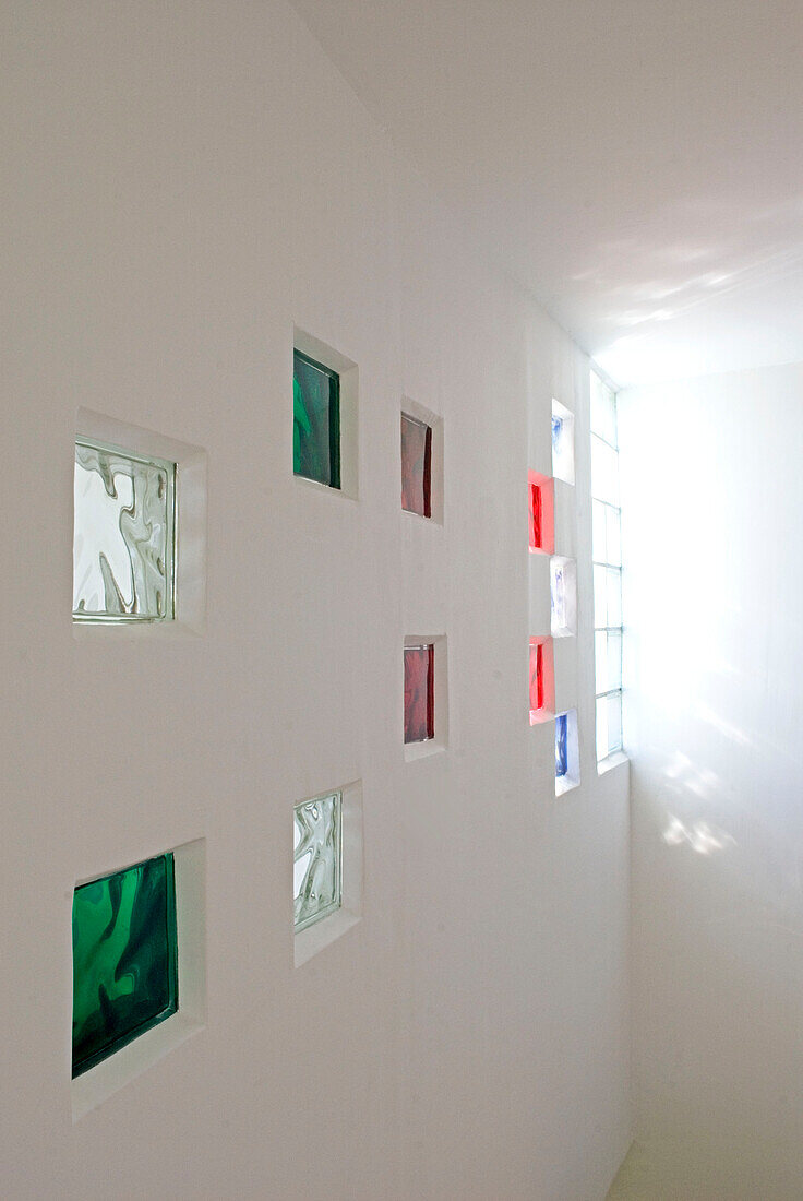Weiße Wand mit farbigen Glasbausteinen