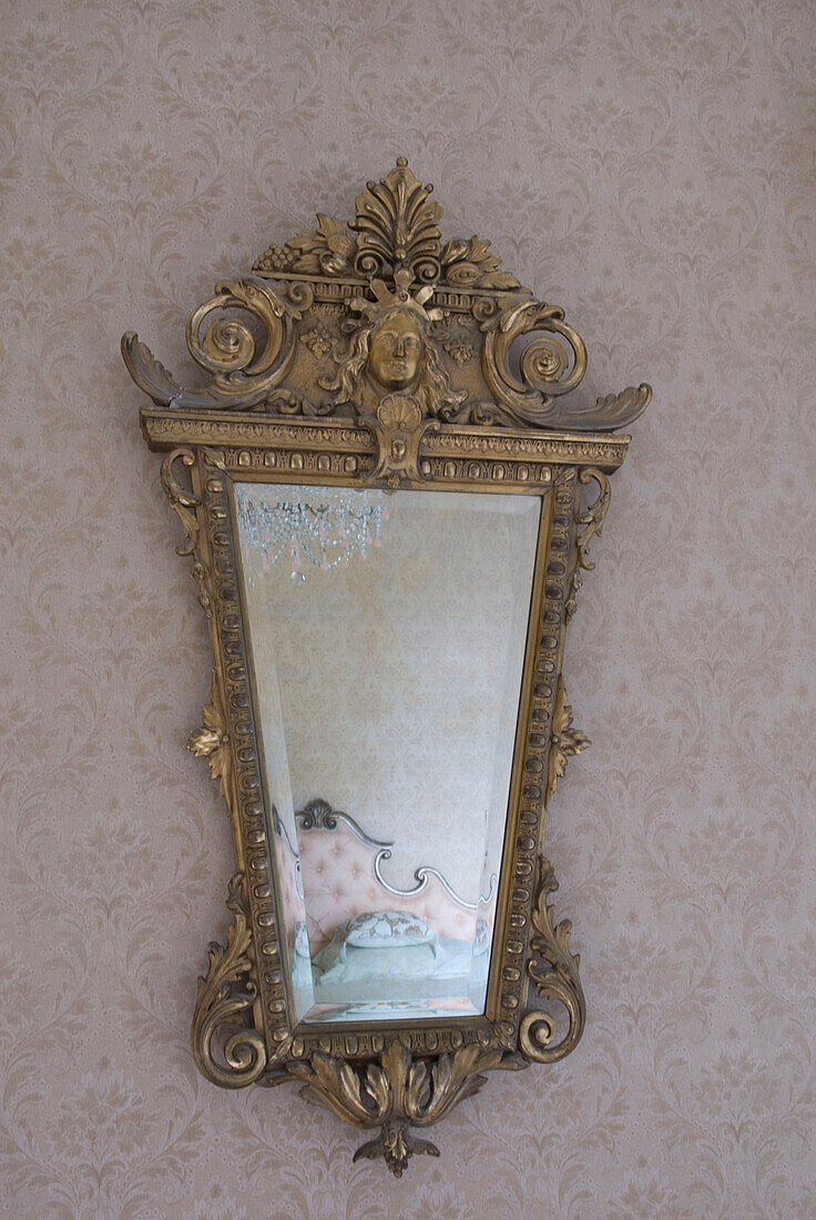 Luxuriöses Bett im verschnörkelten Spiegel