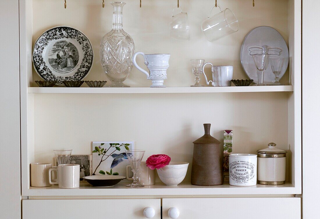 Collection of rustic crockery on kitchen shelf