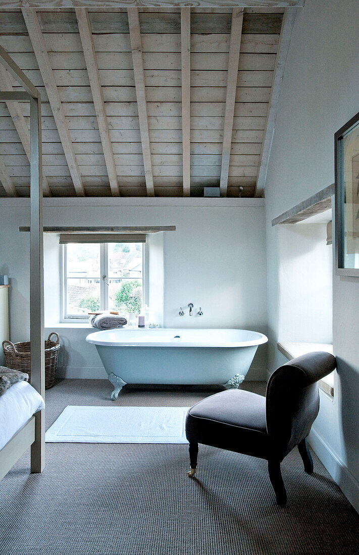 Freistehende Badewanne am Schlafzimmerfenster eines Hauses in Wiltshire