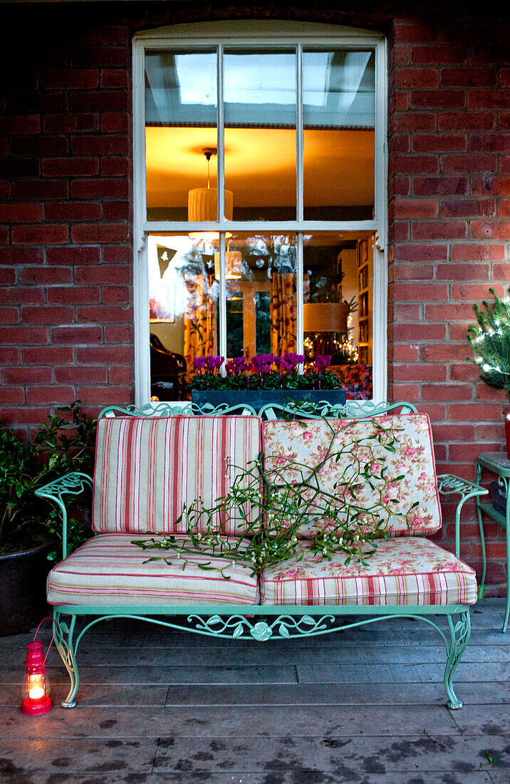 Mistelzweige und Sitzgelegenheiten am Fenster einer Gartenveranda in Hereford