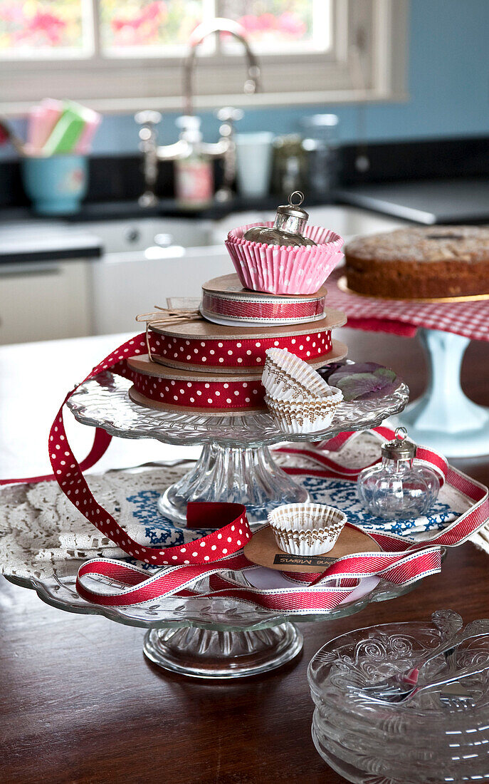 Red spotted ribbon on glass cake stand in 1950s style kitchen