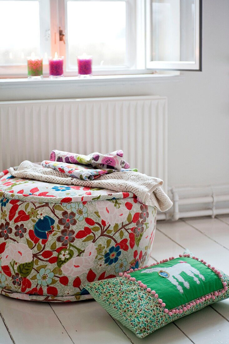 Decken auf einem mit Blumen bedeckten Sitzmöbel in einer Wohnung in Odense