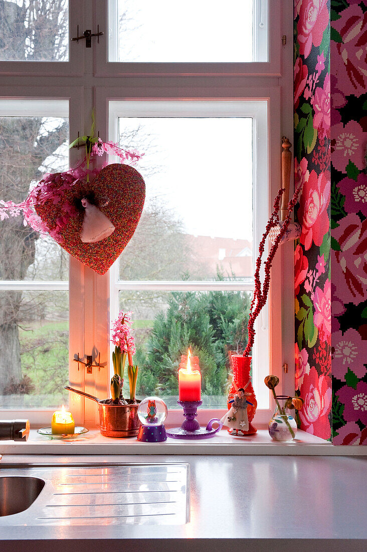 Lit candle with Christmas decorations on Odense kitchen windowsill