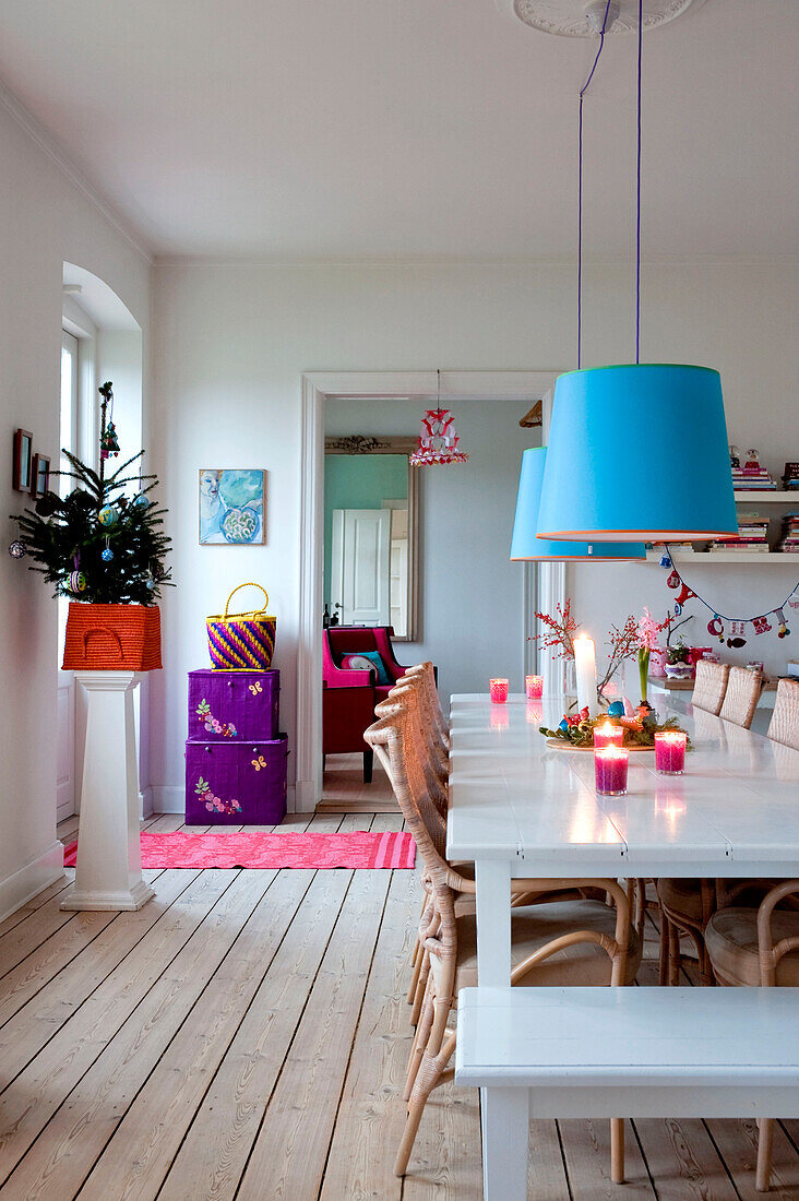 Blue pendant shades hang over painted Odense dining table
