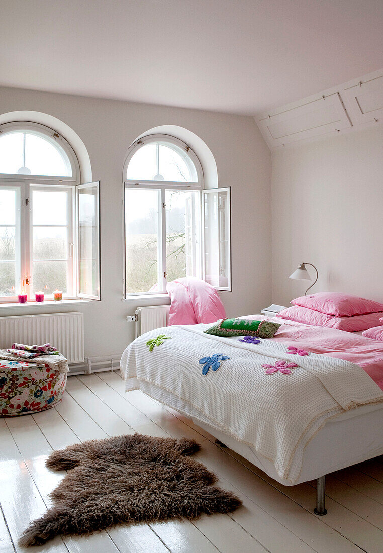 Bettdecke hängt durch offene Fenster im Schlafzimmer in Odense mit Pelzteppich