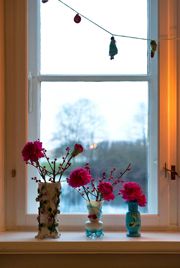 Rosa Nelken in Vasen auf der Fensterbank in Odense