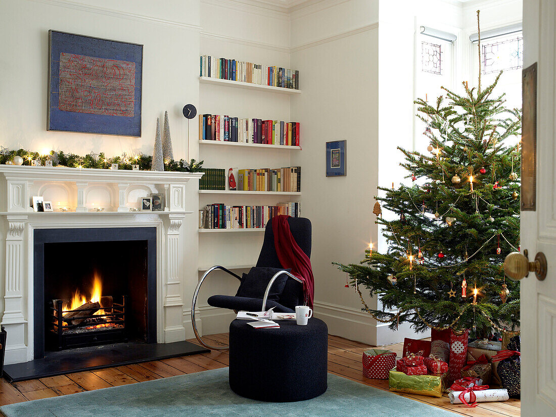 Beleuchtetes Feuer in einem weihnachtlich dekorierten Wohnzimmer
