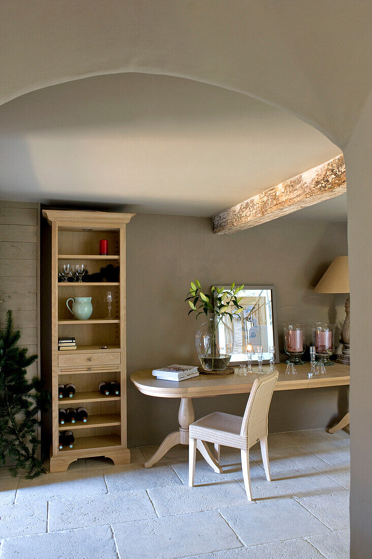Bücherregal und heller Holztisch in einer Bauernhausküche mit Gewölbedecke Wiltshire