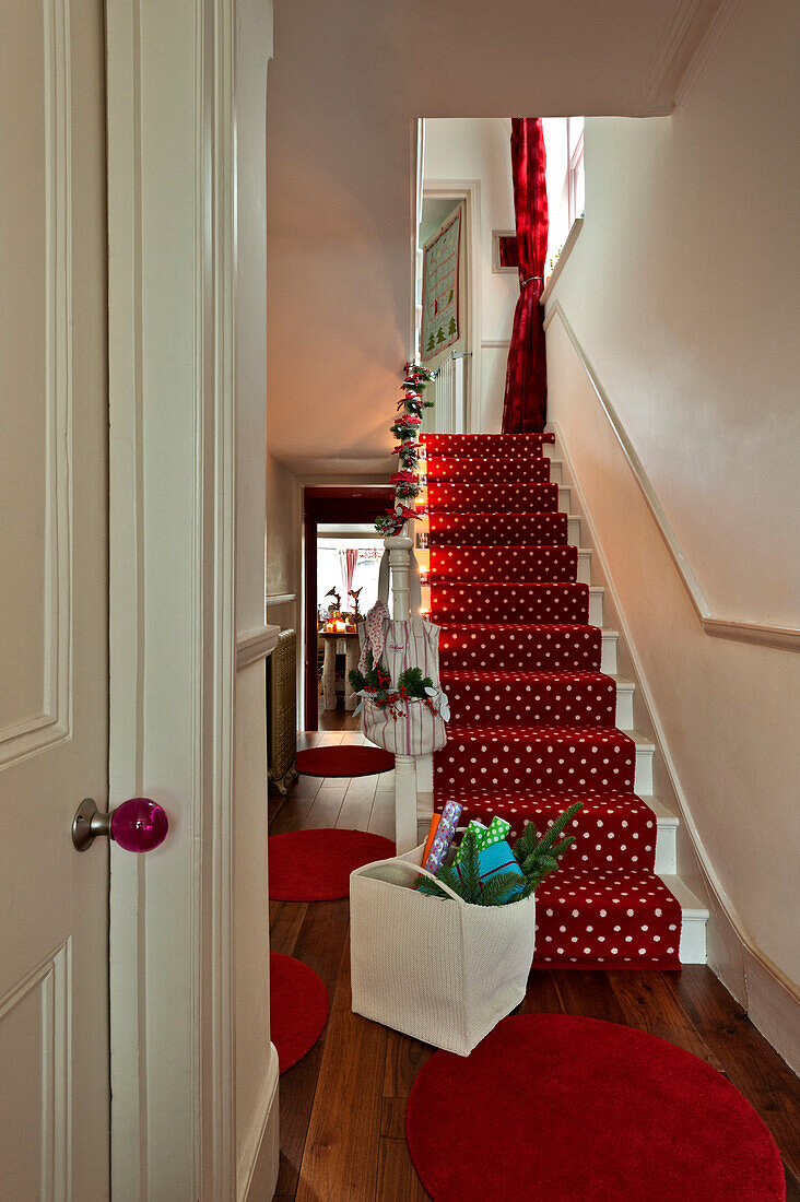 Weihnachtsvorbereitungen im mit rotem Teppich ausgelegten Flur eines Londoner Hauses UK