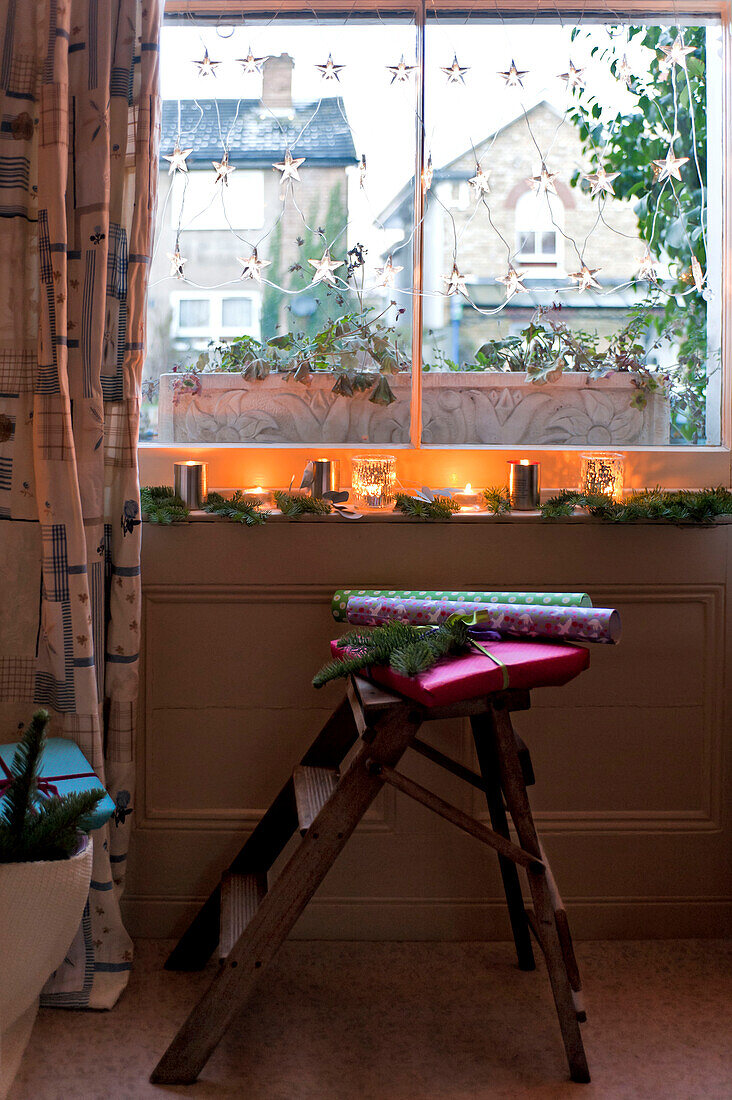 Beleuchtete Kerzen und Tannendekoration auf einem Fenstersims in einem Londoner Haus UK