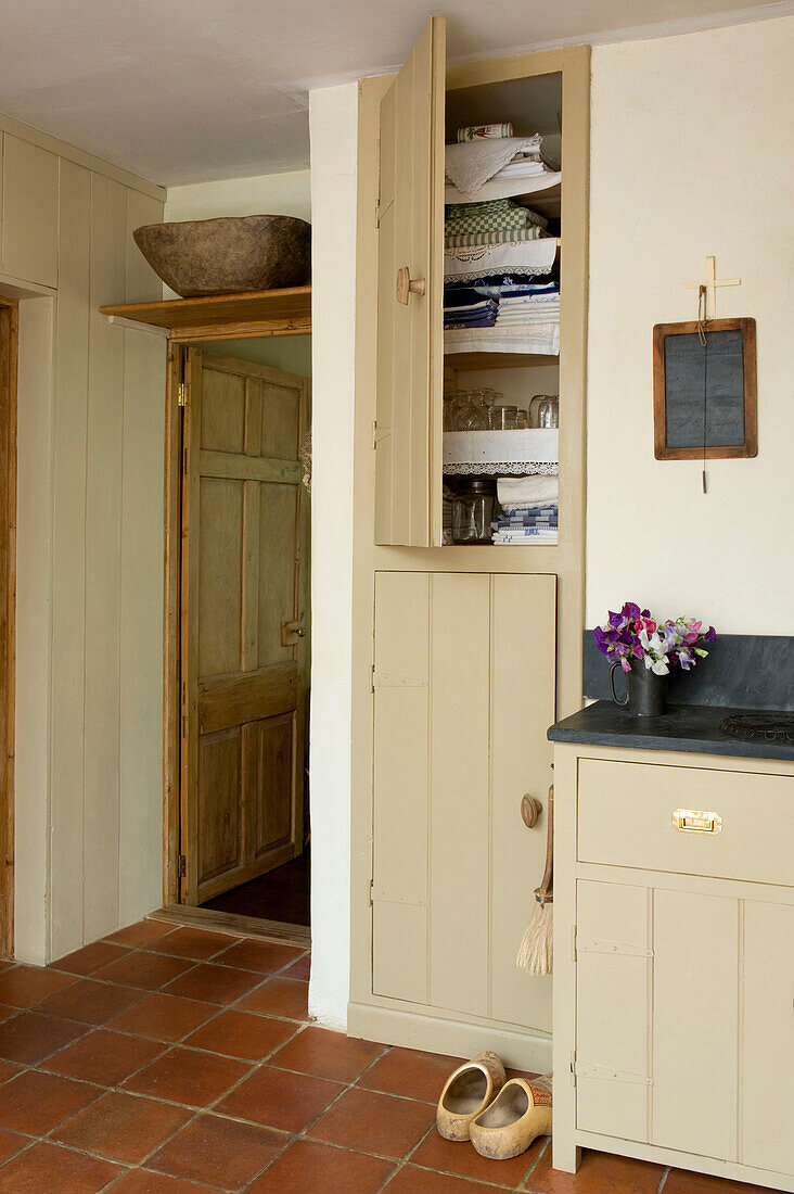 Open storage cupboard in tiled Devon kitchen