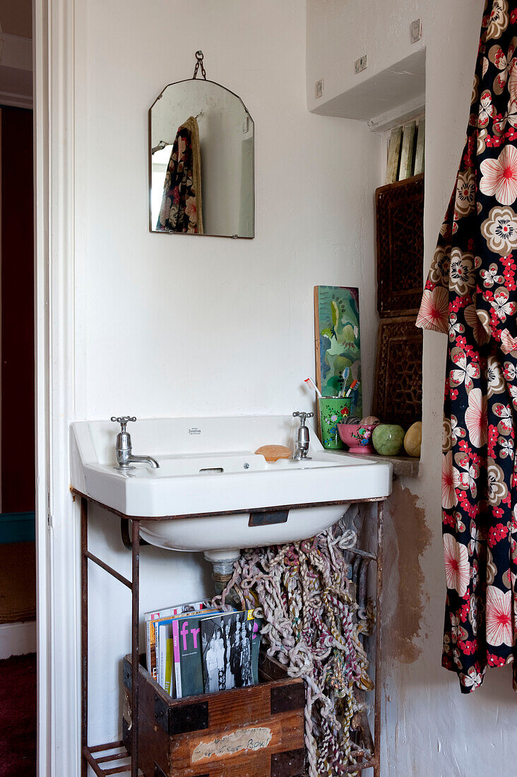 Waschbecken mit Kistenablage und Kimono im Badezimmer eines britischen Hauses