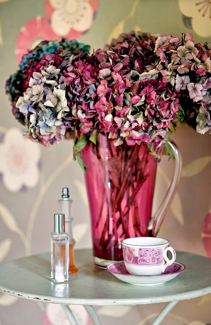Getrocknete Blumen und Parfümflaschen mit Teetasse und Untertasse in einem Londoner Haus UK