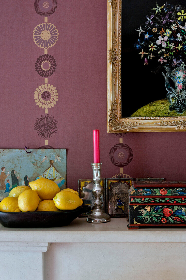 Ornamente und Haushaltswaren mit Zitronen und Kunstwerken auf dem Kaminsims in einem Londoner Haus UK