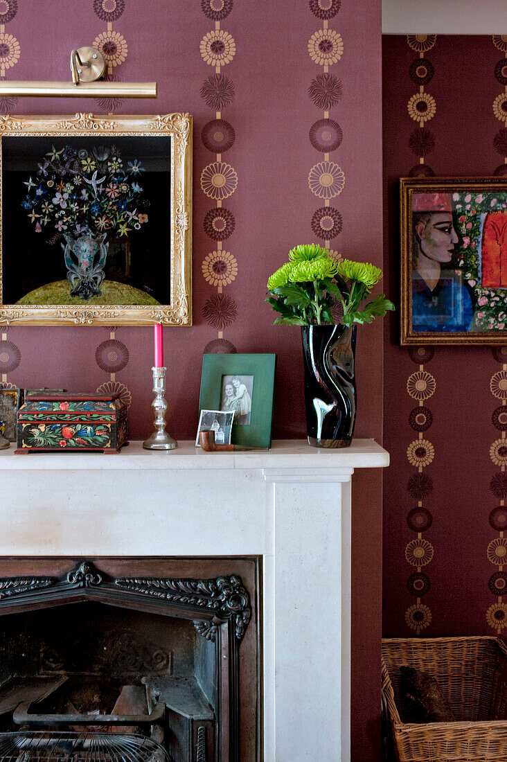 Goldmetallic-Tapete mit Blumenmuster, Marmorkamin und Kunstwerk im Wohnzimmer eines Londoner Hauses UK