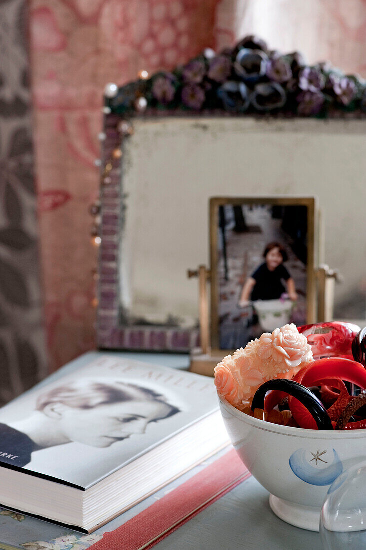 Armbänder in einer Schale mit Buch und Familienfoto auf dem Nachttisch in einem Londoner Haus UK