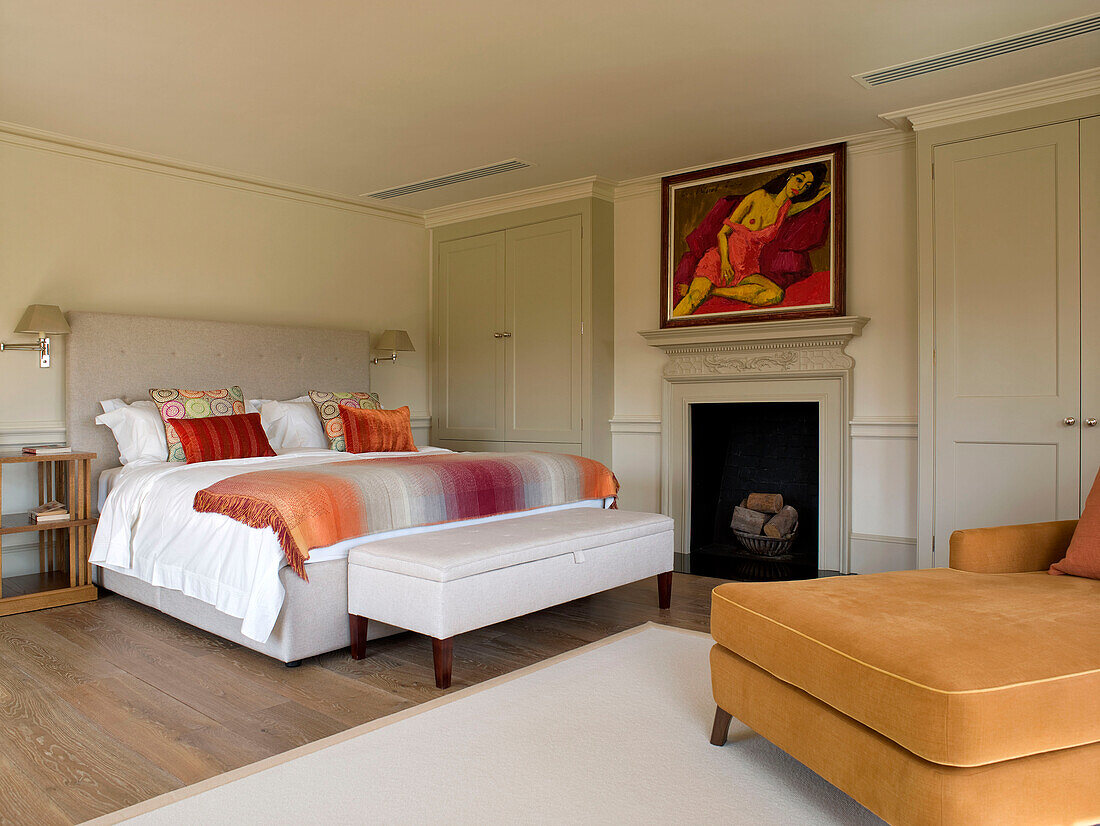 Modern art above fireplace in master bedroom of West London townhouse England UK