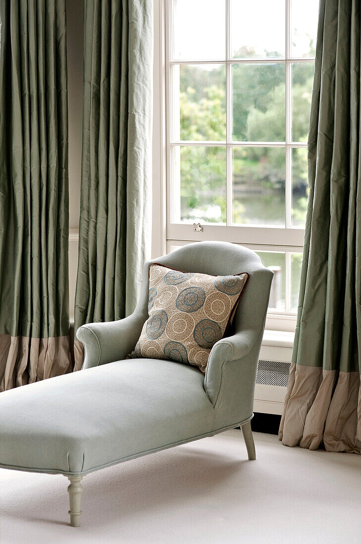 Light green chaise longue at window of West London townhouse England UK
