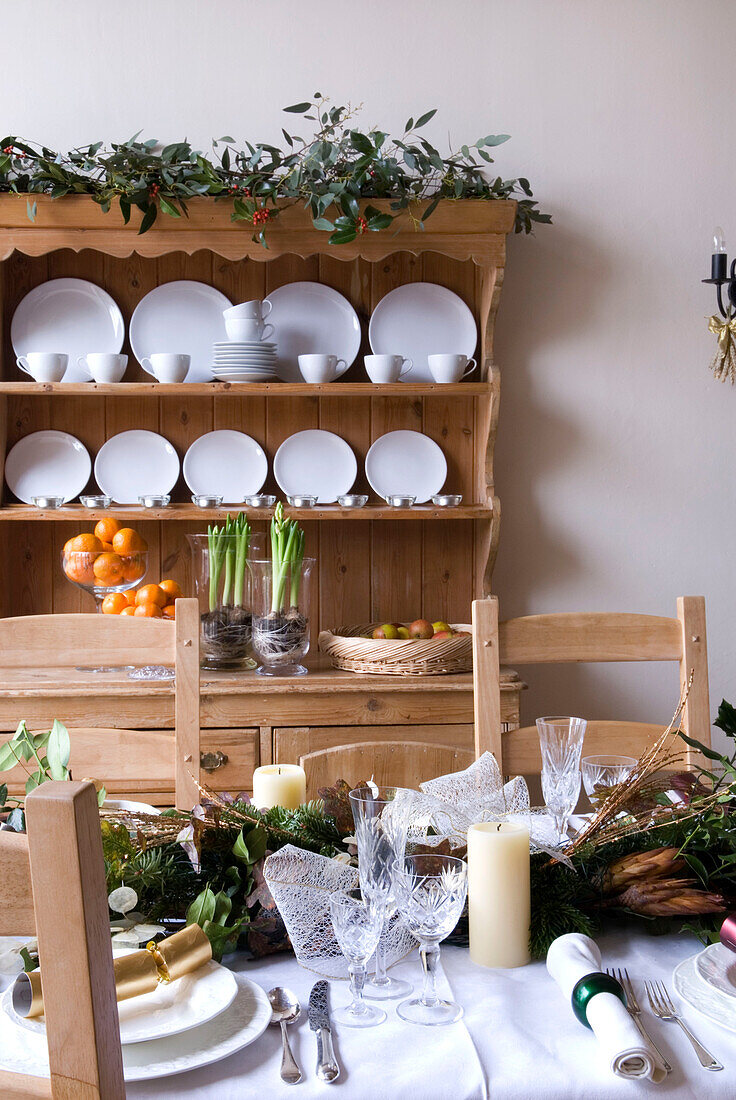 Christmas dining table and pale wood dresser with crockery in rural Suffolk home England UK