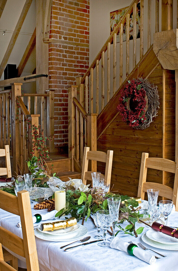 Wooden staircase in open plan dining room of rural Suffolk home England UK