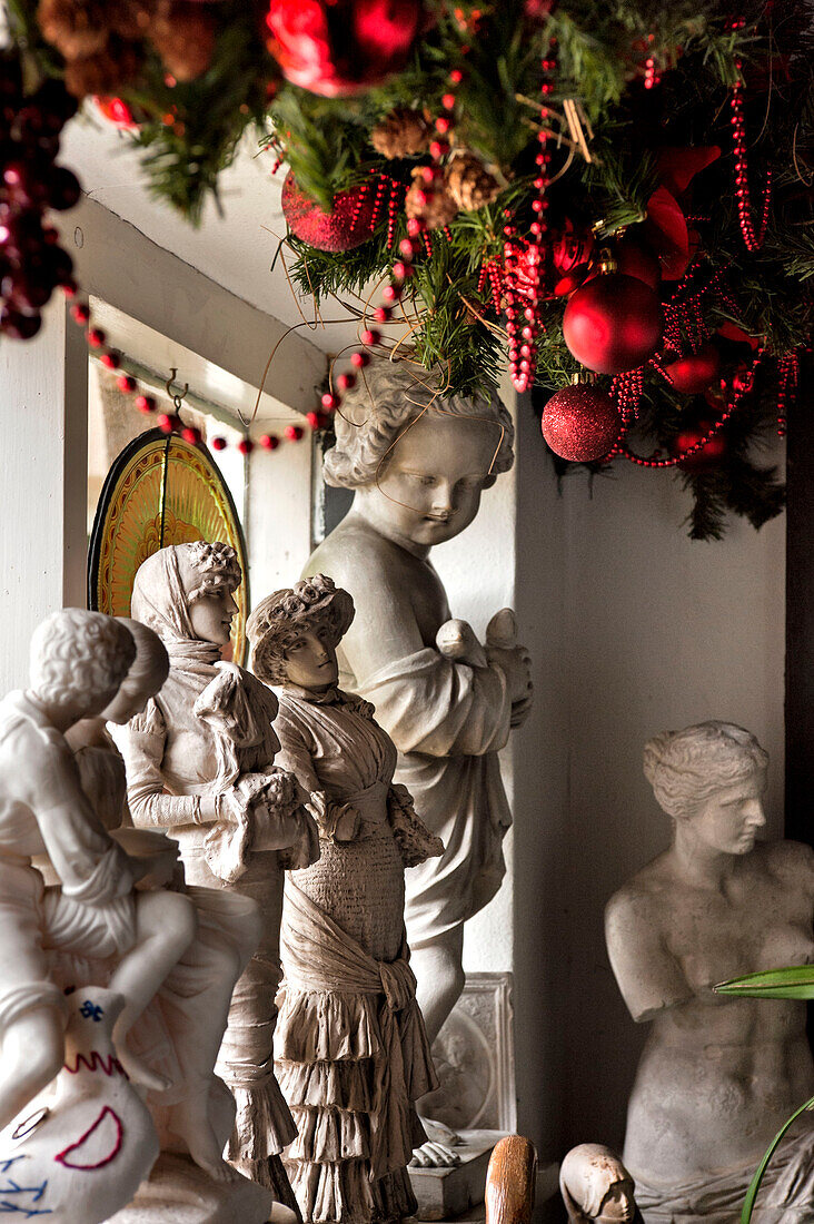 Plaster cast figurines and red Christmas decorations in Cheltenham home Gloucestershire England UK